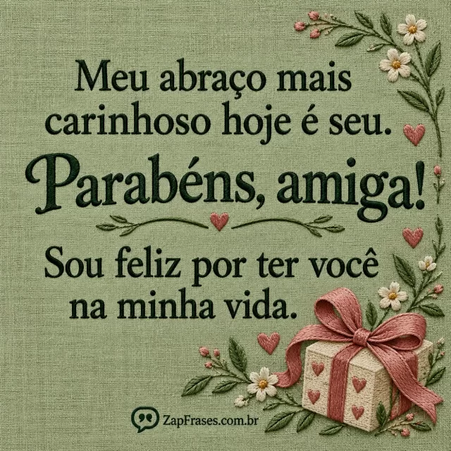 Pequeno presente e laço bordados no canto inferior direito, fundo de linho verde-sálvia opaco; texto serifado verde-profundo claramente impresso.. Arte com a mensagem: Meu abraço mais carinhoso hoje é seu. Parabéns, amiga! Sou feliz por ter você na minha vida.